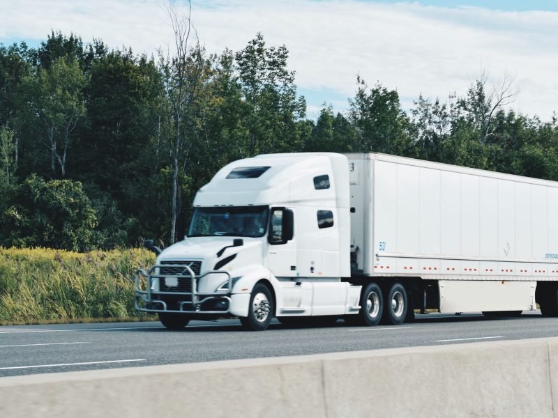 all-white-tractor-trailer-driving-on-a-highway.jpg